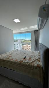 una camera da letto con un letto e una grande finestra di Apartamento 501 Brisa do Sol a Piratuba