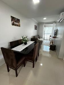 una sala da pranzo e un soggiorno con tavolo e sedie di Apartamento 501 Brisa do Sol a Piratuba