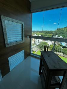 una camera con tavolo in legno e ampie finestre di Apartamento 501 Brisa do Sol a Piratuba