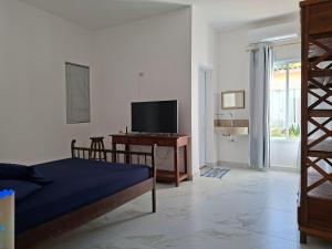 a bedroom with a bed and a desk with a television at Villaggio di Assisi in São Sebastião