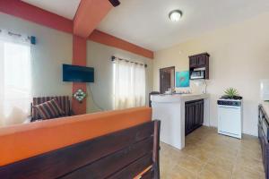 eine Küche und ein Wohnzimmer in Orange und Weiß in der Unterkunft Honey Camp #1 at Laguna Suite -Gold Standard Certified in San Pedro