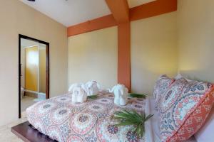 ein Schlafzimmer mit zwei Elefantenfiguren auf einem Bett in der Unterkunft Honey Camp #1 at Laguna Suite -Gold Standard Certified in San Pedro