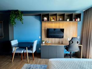 a bedroom with a table and a blue wall at LIV apto 1211 - Loft novo com vista in Porto Alegre