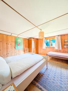 ein großes Bett in einem Zimmer mit Holzwänden in der Unterkunft Appt dans chalet en pleine nature aux Mosses in Les Mosses