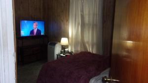 une chambre avec un lit et une télévision dans une pièce dans l'établissement NiceShortStayMassena, à Massena