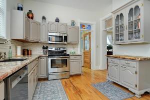 a kitchen with white cabinets and stainless steel appliances at The Caddis Cottage in Salida