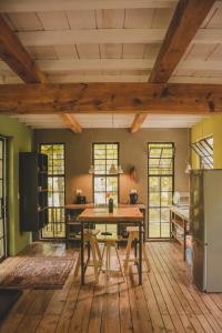 a kitchen with a wooden table and a refrigerator at Porcupine House in Magaliesburg