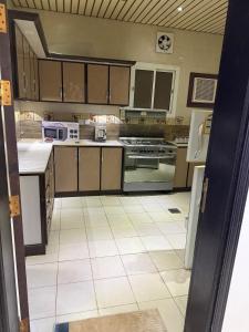 a large kitchen with a white tile floor at Apartment ready for daily rent Quiet, two bedrooms in Al Madinah