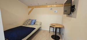 a small room with a couch and a table at Przytulny pokój jednoosobowy ze wspólną łazienką i kuchnią in Kętrzyn