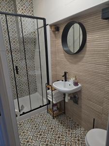 a bathroom with a shower and a sink and a mirror at Przytulny pokój jednoosobowy ze wspólną łazienką i kuchnią in Kętrzyn