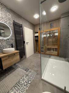 a bathroom with a glass shower and a sink at Pro Home Mara private Sauna in Bad Oeynhausen