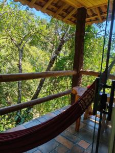 a hammock on the porch of a tree house at Chalés Isa e Ana in Itatiaia