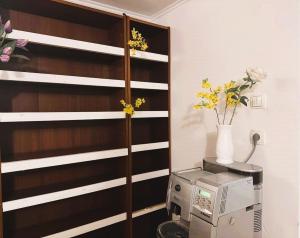 a kitchen with a microwave and flowers on a shelf at Opera Stay in Budapest