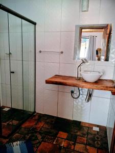 Un baño con lavabo, espejo y ducha. en Chalés Isa e Ana, en Itatiaia 31 fotos más