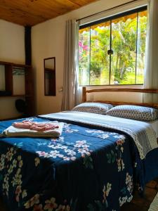 two beds in a bedroom with a window at Chalés Isa e Ana in Itatiaia +41 photos