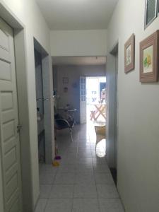 einen Flur mit einer Tür und ein Zimmer mit einem Tisch in der Unterkunft Hostel da Josi - Porto de Galinhas in Porto De Galinhas + 1 Foto