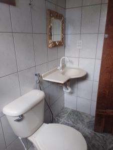 a bathroom with a white toilet and a sink at Sitio Recanto das águas in São João del Rei