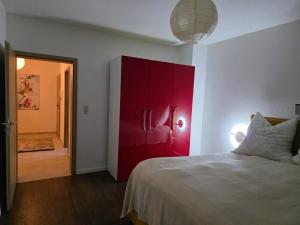 a bedroom with a red cabinet and a bed at Bello in Wallerfangen +7 photos