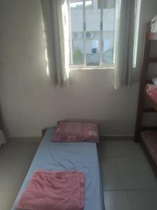 a small room with a bed and a window at Xixova hostel in São Vicente