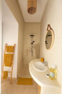un baño con lavabo y espejo en Dar Oumnass, charme authentique tout confort !, en Oumnas
