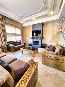 Una gran sala de estar con sofás y chimenea. en Villa Amroth, en Marrakech