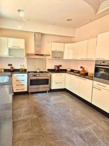 cocina grande con armarios blancos y electrodomésticos de acero inoxidable en Villa Amroth, en Marrakech