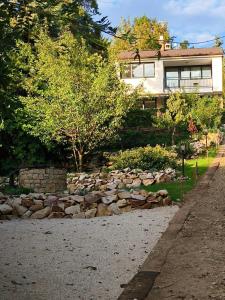 a house with a pile of rocks in front of a yard at Gödöllő Country Home in Gödöllő
