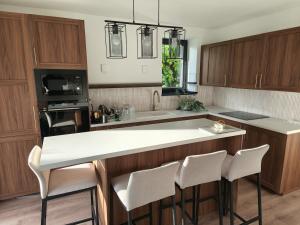 a kitchen with wooden cabinets and a white counter top at Gödöllő Country Home in Gödöllő +8 photos