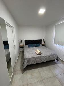 a bedroom with a bed in a white room at Complejo de departamentos H&H in Guaymallen +28 photos