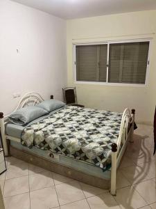 a bedroom with a bed in a room with a window at 5 minutes from the beach in Mindelo