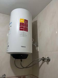 a white water tank on the wall of a bathroom at 5 minutes from the beach in Mindelo