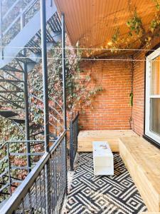 einen Balkon mit einem Tisch und einer Ziegelwand in der Unterkunft La Pause Montréal in Montreal