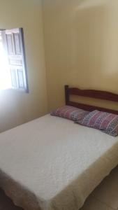 a bed in a bedroom with a window at Recanto Zen centro Cumuruxatiba in Cumuruxatiba