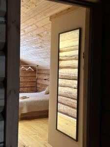 a mirror in a room with a bed in the background at Stone & Forest Spa in Ternopil
