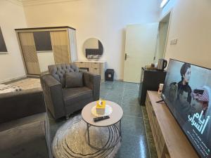a living room with a couch and a tv at ANA Apartment2 in Hail