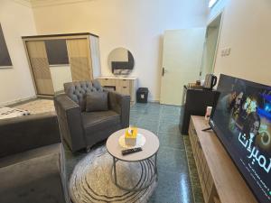 a living room with a couch and a tv at ANA Apartment in Hail