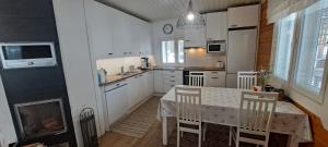 a kitchen with a table and chairs and a stove at Log cottage by the lake in Kuopio