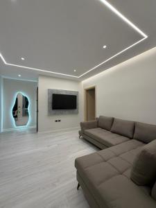 a living room with a couch and a flat screen tv at Chic Apartament Free Parking in Vlorë