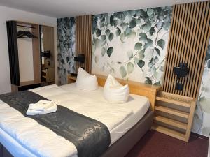 sypialnia z dwoma łóżkami i ścianą z kwiatami w obiekcie Hotel Annablick w mieście Strausberg
