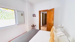 a white bedroom with a bed and a window at Terraza del Mar in Arrieta +18 photos