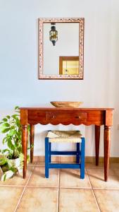 a wooden table with a blue stool under a mirror at Terraza del Mar in Arrieta