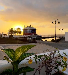 een gebouw op het strand met de zonsondergang op de achtergrond bij Terraza del Mar in Arrieta