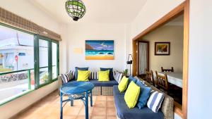 a living room with a blue couch and yellow pillows at Terraza del Mar in Arrieta