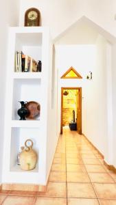a hallway with white walls and a floor with a clock at Terraza del Mar in Arrieta