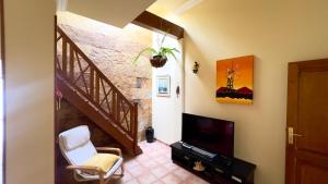een woonkamer met een trap en een televisie bij Terraza del Mar in Arrieta