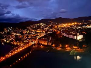 a view of a city at night with lights at Podzámčí - útulný byt na nábřeží pod zámkem in Děčín