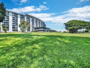 a large building with a grass field in front of it at Hilo Lagoon Center #911 in Hilo