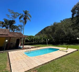 a swimming pool in a yard next to a house at Aconchegante SÍTIO com piscina em Bom Jardim in Bom Jardim