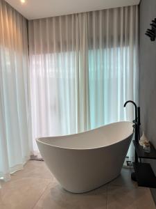a white bath tub sitting in front of a window at Cipó Lofts - Serra do Cipó in Santana do Riacho +20 photos