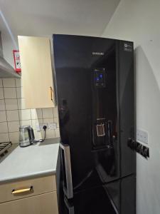 een zwarte koelkast in een keuken naast een aanrecht bij 1Bedroom Apartment in Central Northampton in Kingsthorpe +6 foto's